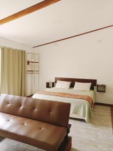 a large bedroom with a bed and a couch at Green Lodge Eco Life in Florianópolis