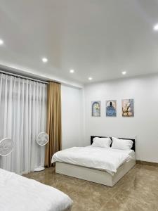 Ðình LoanにあるMàn Thầu Homestayの白いベッドルーム(ベッド2台、窓付) +3枚の写真