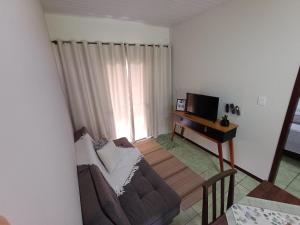 a living room with a couch and a television at Casa Amora - 2 Quartos in Pomerode