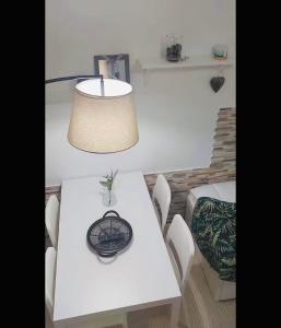 a white table with white chairs and a lamp at Casa da Tia Binda - refúgio no centro histórico in Monção +18 photos