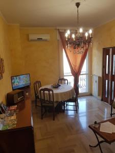 a dining room with a table and chairs and a chandelier at Casa Marisa in Albenga