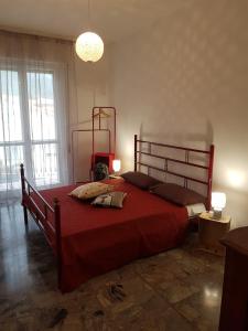 a bedroom with a large bed with a red bedspread at Casa Marisa in Albenga