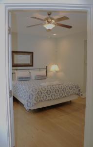 Un dormitorio con una cama y un ventilador de techo. en 410A The Jetty House, en Virginia Beach