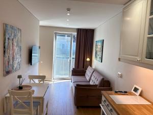 a living room with a couch and a table at Marios laiko apartamentai Juodkrantėje in Juodkrantė