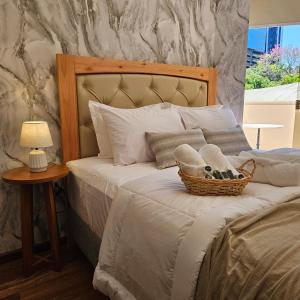 a bed with a basket of shoes and a lamp at Green Palace Hotel Boutique in Asuncion