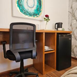 a computer chair sitting next to a desk with a speaker at Green Palace Hotel Boutique in Asuncion