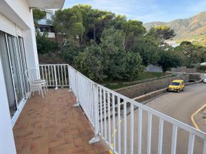 a balcony with a white railing and a yellow car at La Cantonada in Port de la Selva