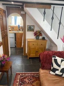 a living room with a couch and a kitchen at Cosy cottage in Torquay