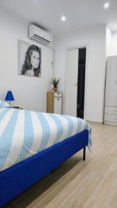 a blue and white bed in a room at Roca House in Valenzano