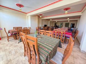 a restaurant with wooden tables and chairs at Hotel Elom in Uyuni
