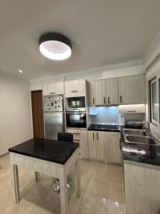 a kitchen with a table and a black counter top at Spacious & Fully Equipped 2-Bedroom Apartment in Heraklion in Heraklio +9 photos