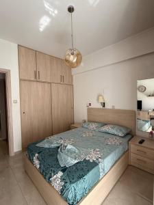 a bedroom with a bed with a green comforter at Spacious & Fully Equipped 2-Bedroom Apartment in Heraklion in Heraklio