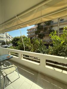 a balcony with a table and a chair and an umbrella at Spacious & Fully Equipped 2-Bedroom Apartment in Heraklion in Heraklio