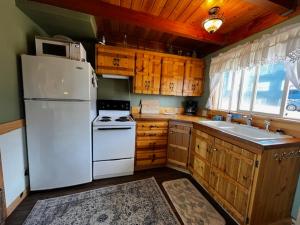 ニューポートにあるKrakens Koveのキッチン(白い冷蔵庫、木製キャビネット付)