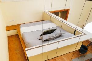 a small bed in a room with a mirror at Historic Loft Overlooking Plaza de Armas in Santiago
