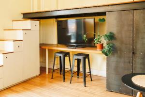 a room with a desk with two stools and a tv at Historic Loft Overlooking Plaza de Armas in Santiago