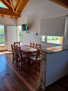 a dining room with a wooden table and chairs at La Chabela 02 in Trevelín