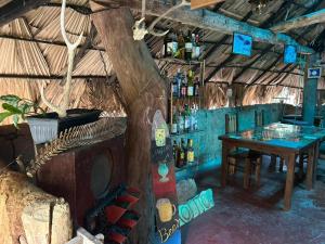una stanza con un tavolo e bottiglie di vino di Hasthi Safari Cottage a Udawalawe