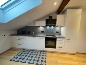 Mils bei HallにあるQuartier 27の屋根裏のキッチン(白いキャビネット、シンク付)