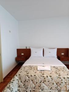 a bedroom with a bed with a blanket and two night stands at Misky Puñuy in Chiclayo
