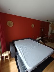 Un cocon en plein cœur de la Mongie في لا مونجي: سرير في غرفة بجدار احمر