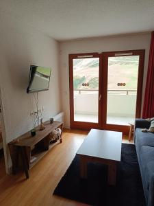 Un cocon en plein cœur de la Mongie في لا مونجي: غرفة معيشة مع أريكة وطاولة