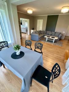 een woonkamer met een tafel, stoelen en een bank bij Semo guest house 2 with hot tub in Vecumnieki