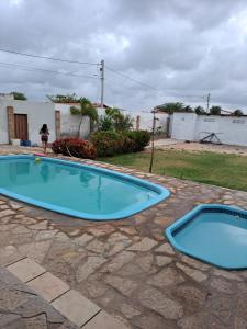 a woman standing in front of a swimming pool at pousada Requenguela in Icapuí