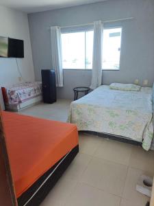 a bedroom with two beds and a window at pousada Requenguela in Icapuí