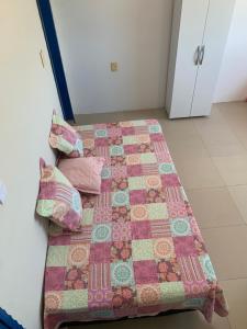 a bed with a quilt and pillows on it at pousada Requenguela in Icapuí +2 photos
