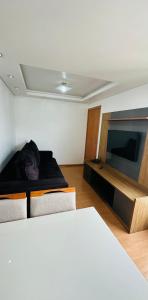 a person laying on a bed in a room with a television at Ap 2 Quartos 5km da BR, Palhoça in Palhoça +10 photos