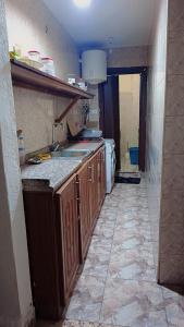 a kitchen with wooden cabinets and a tile floor at وسط البلد عمان in Amman