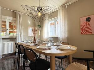 a dining room with a table with chairs and a chandelier at Urban Hideaway Rastatt by Gassling Homes in Rastatt