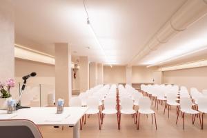una sala de conferencias con mesas y sillas blancas en Hotel Raffaello, en Milán