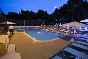 a swimming pool with chairs and a fire hydrant at Hotel Pula in Pula