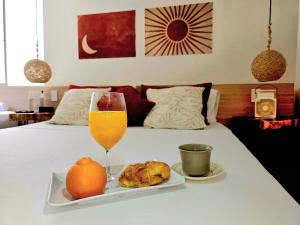 un plato de fruta y un vaso de zumo de naranja en la cama en KA'I KASHI - Modern Apartment close to beach, en Ríohacha