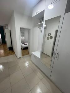 a bathroom with white walls and a mirror at Stan na dan - Apartman Genex 
