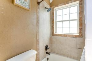 a bathroom with a white tub and a window at 2 Mi to Fort Sill Quiet Family Retreat with Yard in Lawton +17 photos