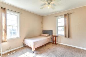 a bedroom with a bed and a table and windows at 2 Mi to Fort Sill Quiet Family Retreat with Yard in Lawton