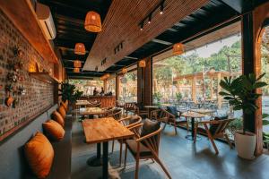 a restaurant with wooden tables and chairs and windows at Ruby Homestay in Ninh Binh