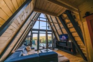a living room with a blue couch and a large window at RentiGo A-Frame in Ledinci