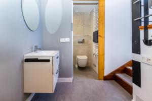 une petite salle de bain avec un lavabo et des toilettes dans l'établissement BaruHaus triplex piscina y parking, à Villamañán 13 autres photos