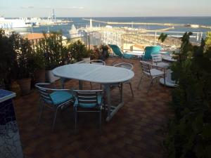 un patio avec une table et des chaises et l'océan dans l'établissement Sète chambre d'hôtes belle vue le quartier haut, à La Celle-sous-Gouzon