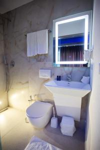 a bathroom with a sink and a toilet and a mirror at Standard Room at The Bubbles Jacuzzi Rooms in Tirana