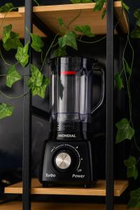 a black blender sitting on a wooden shelf at Apartamento Frente ao Mar no Embaré Moderno Completo com Vaga in Santos
