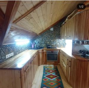 een keuken met houten kasten en een kookplaat met oven bij Корінь in Krasnoilov