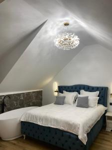 Un dormitorio con una cama azul y una lámpara de araña. en EleS Chalet, en Brebu