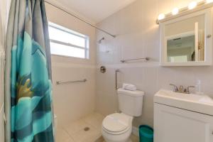 a bathroom with a toilet and a sink and a window at Walk to The Cove! Central Deerfield Beach Home in The Cove +17 photos