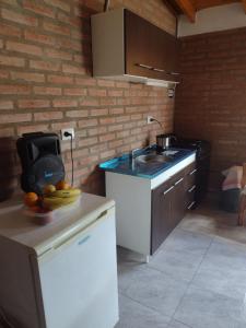 a kitchen with a sink and some fruit on a counter at Casita traslasierras in San Lorenzo