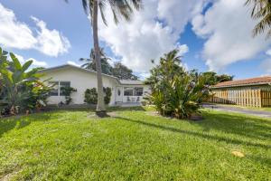 a house with a palm tree in a yard at Walk to The Cove! Central Deerfield Beach Home in The Cove